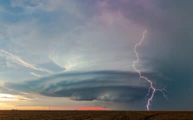 A bolt of lightning strikes ahead of a beautifully sculpted mesocyclone on a storm near Sublette, Kansas on May 21, 2020